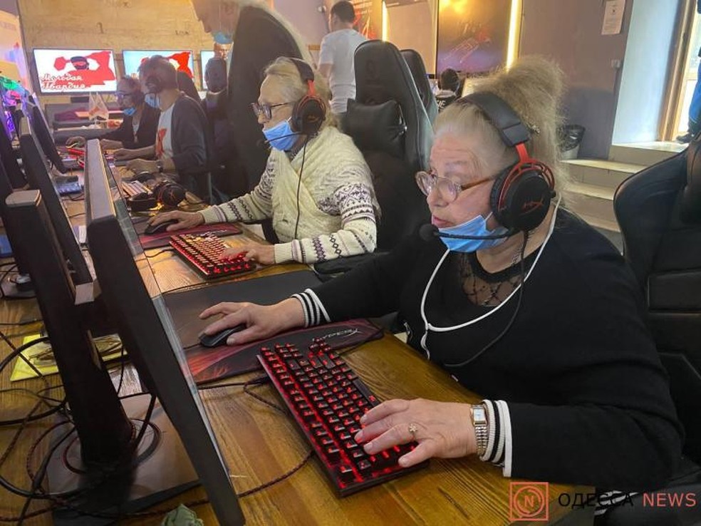 Dois jogadores jogando jogos multijogador em um computador potente em casa  com fones de ouvido profissionais