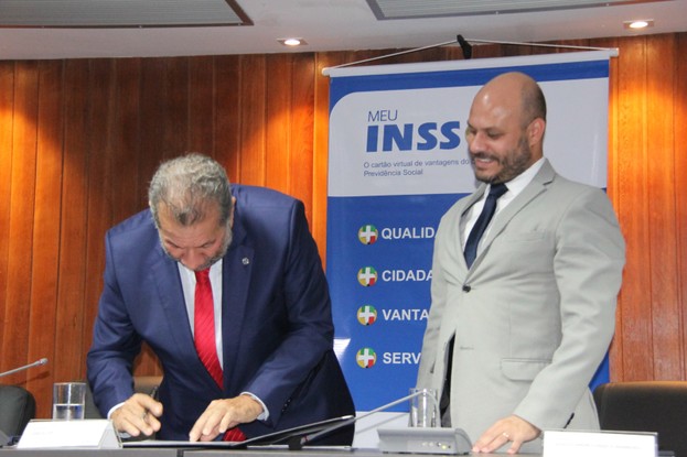 Ministro da Previdência, Carlos Lupi, e o presidente interino do INSS, Glauco André Fonseca Wamburg, durante  da portaria