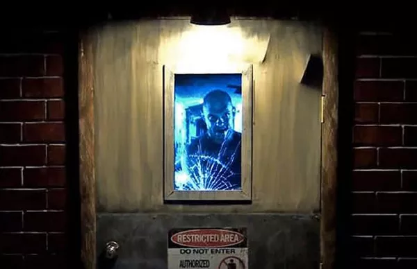 Um homem com uma cara assustadora está atrás de uma porta.