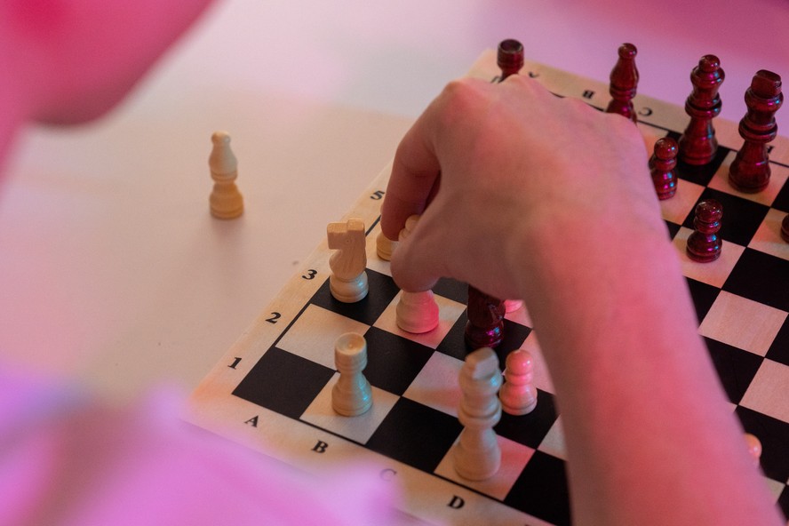 mão de robô de desenho de linha contínua segurando o peão de xadrez para  derrubar o