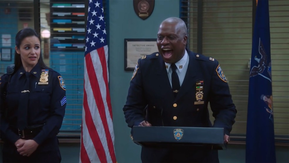 O Capitão Holt gargalha descontroladamente com a "pegadinha" de terem movido seu púlpito em meia polegada em Brooklyn 99 — Foto: Reprodução/Blooklyn Nine-Nine