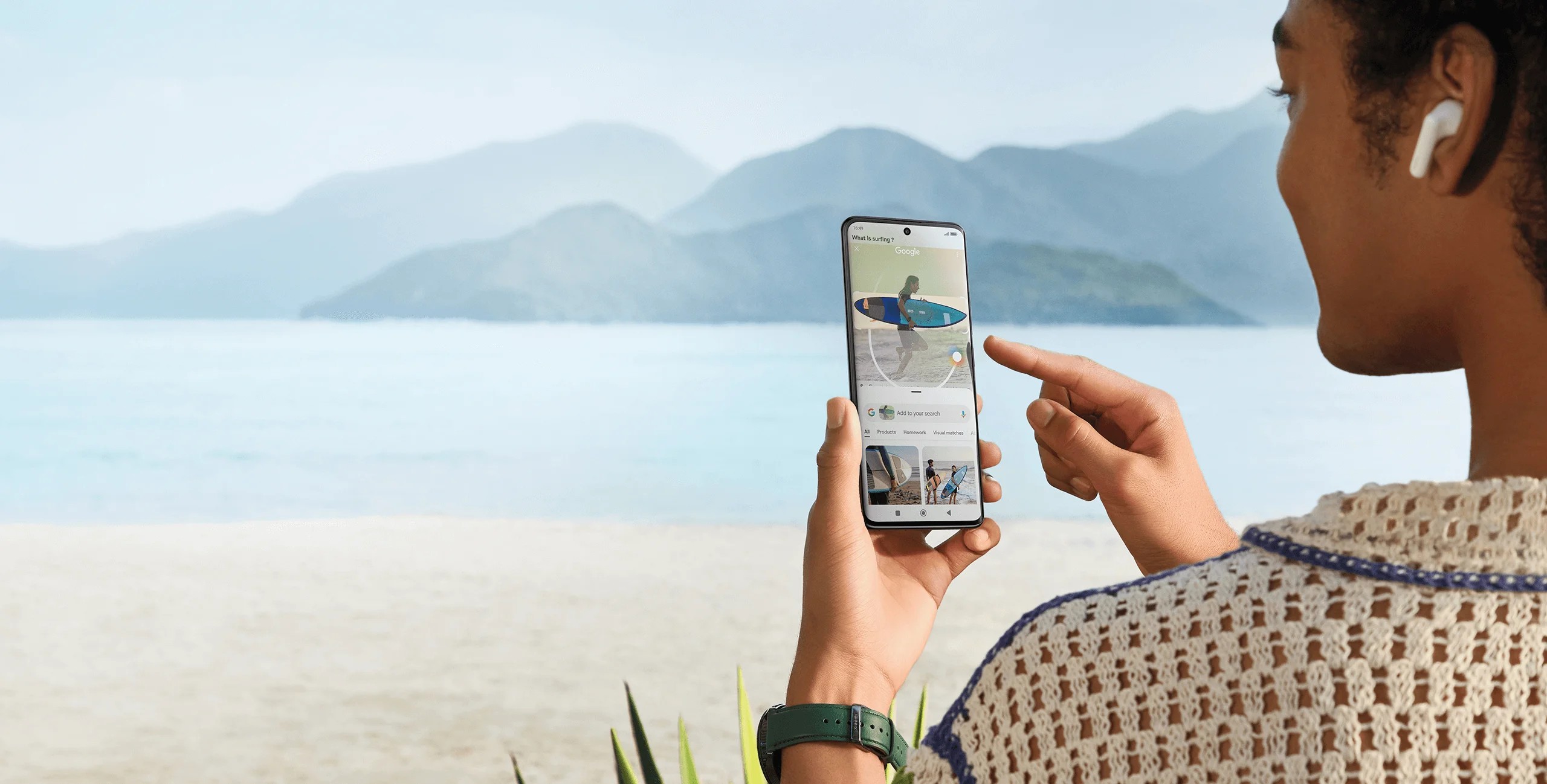 A-frente-do-mar-uma-mulher-de-costas-visualiza-imagens-no-celular-Xiaomi A-frente-do-mar-uma-mulher-de-costas-visualiza-imagens-no-celular-Xiaomi