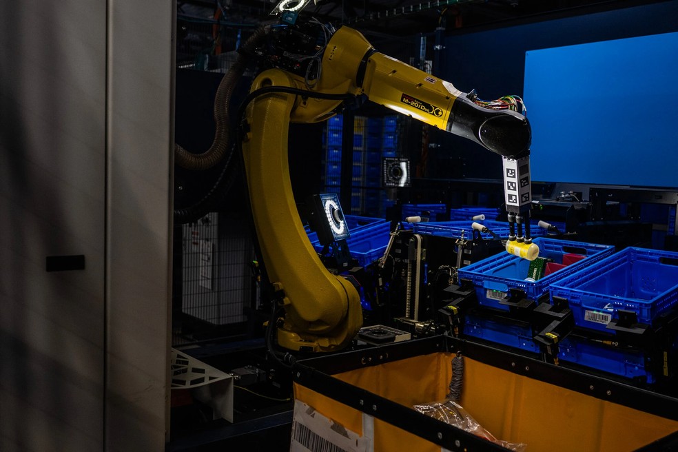 Robôs já são parte crucial do processo de distribuição das compras na Amazon — Foto: Reprodução/The New York Times