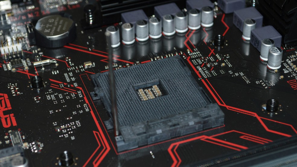 Placa-mãe preta e vermelha com close no soquete da CPU — Foto: Reprodução/Unsplash (Thomas Jensen)