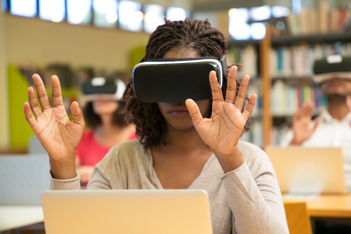 Grupo de jovens com óculos vr em um jogo de realidade virtual em uma luz  azul mirando com armas futuristas ou conceito de tecnologia científica