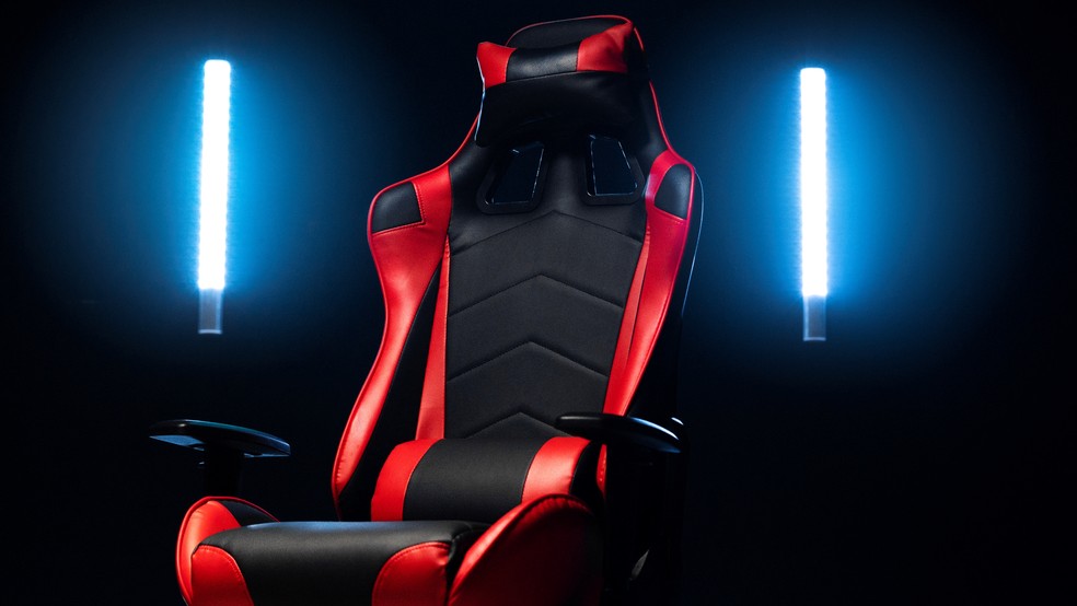 Cadeira gamer ergonômica vermelha e preta em ambiente escuro iluminado por barras de LED — Foto: Reprodução/Freepik